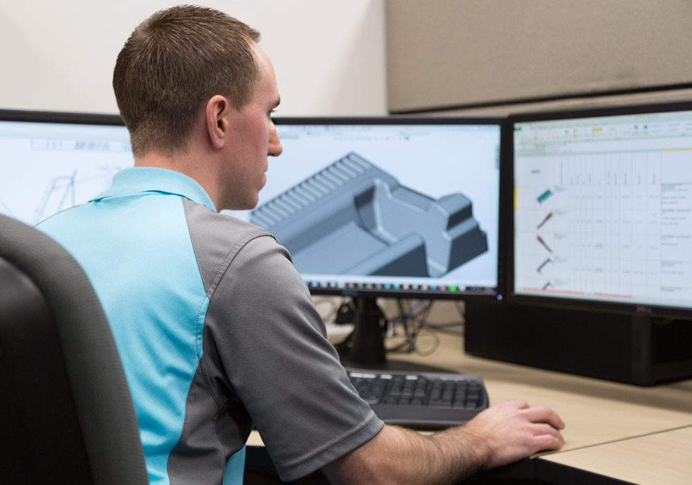 Engineer reviewing CAD models on a workstation